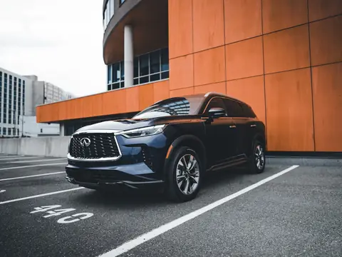 A new dark SUV parked beside a modern building