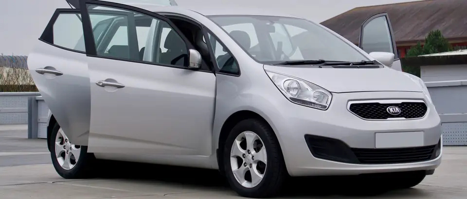 A silver minivan parked with all its doors open